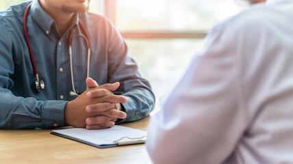 Doctor discussing with patient at desk in medical room