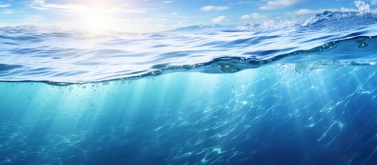 The transparent blue water has a sun glare creating a captivating wave texture background perfect for a copy space image