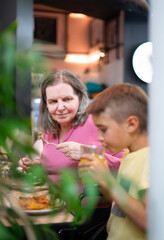 Family of grandmother and her grandson eating together in a restaurant