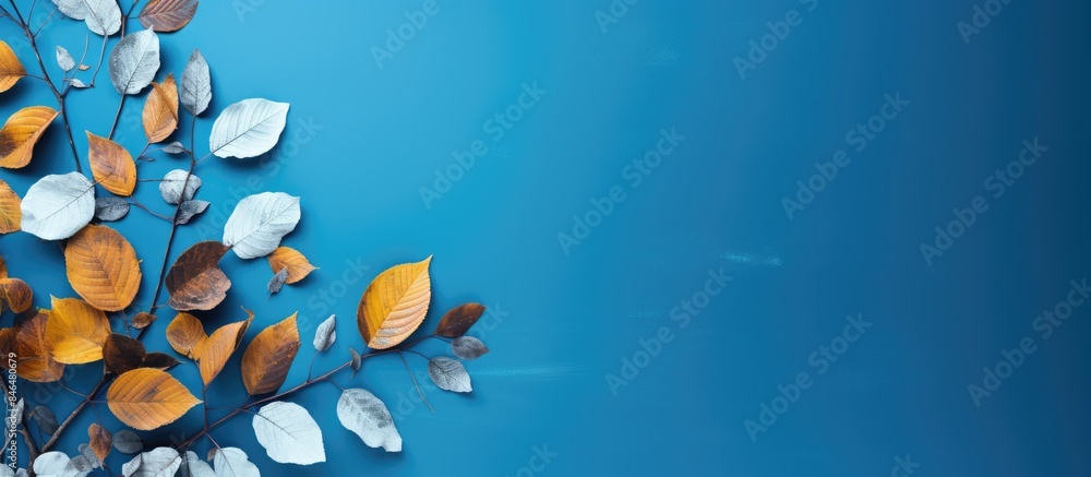Poster In a vivid blue backdrop autumn leaves spread across leaving ample copy space for capturing the image