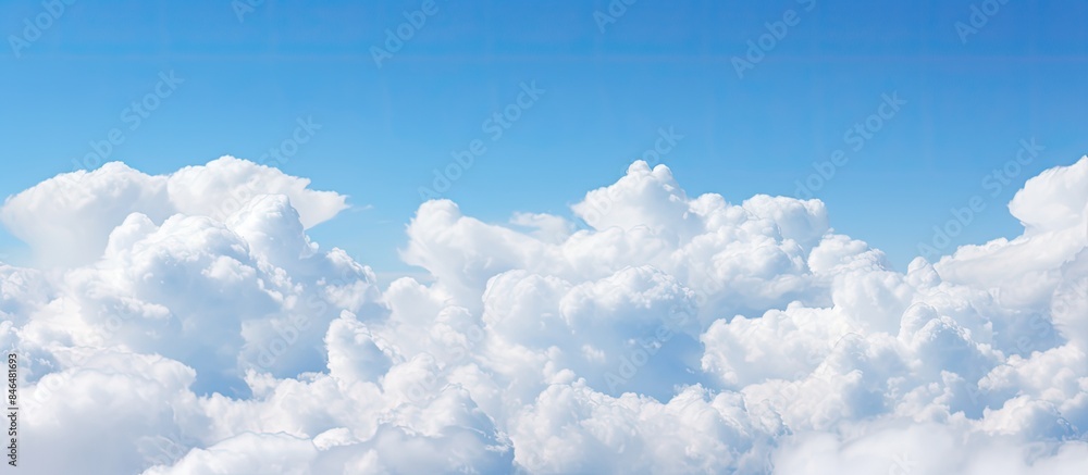 Aufkleber Fluffy white clouds floating in a clear blue sky providing ample empty space for an image
