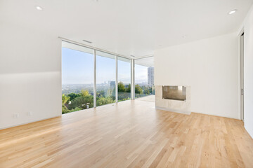 Obraz premium Spacious empty living room with wooden floors and city view