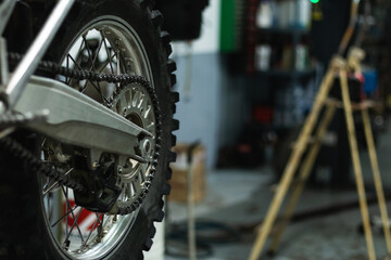 Closeup of mechanic changing motorbike wheel tire with pneumatic wrench in auto service