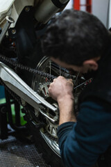 mechanic fixing motocycle wheel
