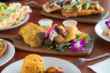 a table with plates of food and a wooden board with a bunch of bread and