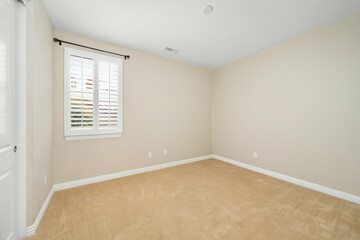 Empty room with tan walls and a window with blinds. California, USA