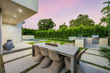 Outdoor table and chairs on a patio with green vegetation in the background. California, USA