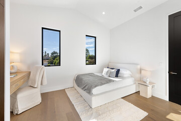 Modern bedroom with a bed and desk positioned by a window
