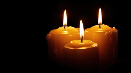 Three glowing candles in the dark create a warm, serene ambience perfect for relaxation, meditation, or a peaceful evening atmosphere.