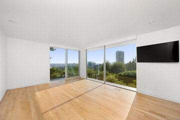 Modern bedroom with hardwood floors and a wall-mounted television