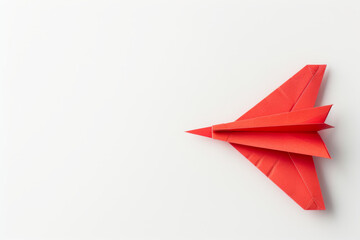 Red origami paper airplane on a white background, symbolizing creativity, innovation, and simplicity in design.