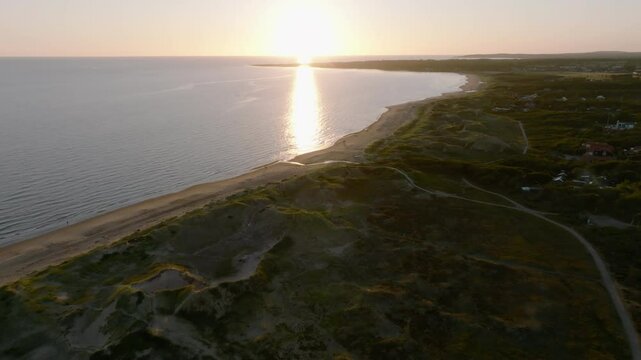 Drone push in over beach and sea in summer sunset