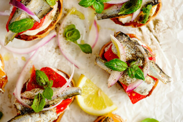 Crostini with sardines, tomatoes, mayonnaise and basi .top veiw