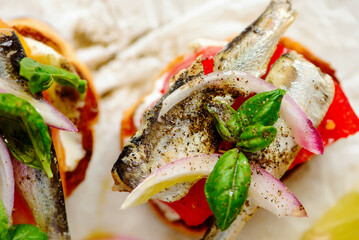 Crostini with sardines, tomatoes, mayonnaise and basi .top veiw