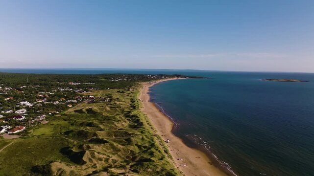 Push in drone view of beach, greenery and sea on sunny summer day