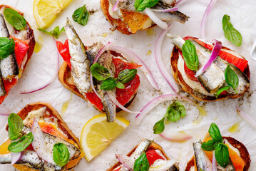Crostini with sardines, tomatoes, mayonnaise and basi .top veiw