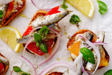 Crostini with sardines, tomatoes, mayonnaise and basi .top veiw