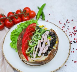 Delicious baked potato topped with ground beef, tomatoes, corn, peas, and green peppers