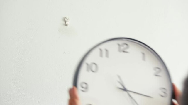 Man taking a clock off the wall