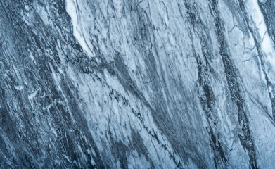 Gray marble texture with natural white veining patterns. Smooth, polished stone surface for countertops