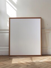 Fototapeta premium Poster bianco in cornice di legno appoggiato a una parete