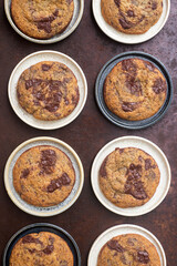 Homemade chocolate chip cookies in ceramic plates on rustic background.