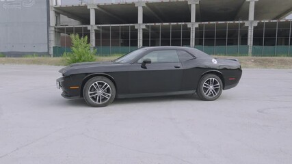 Iconic Black Dodge Challenger, embodying American muscle car prowess, in this thrilling video.