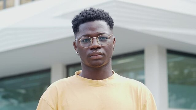 Portrait of a young African American man looking at camera seriously in a city