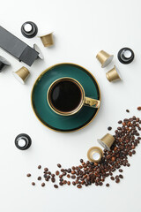 Coffee capsules and beans, cup with coffee drink on white background, top view