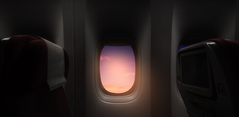 Aerial view through airplane window high above orange sunset sky,Inside Passenger plane seat looking out at beautiful yellow sunrise cloud,Banner transport for Travel,Business Trip,Holiday Vacation