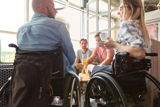 People interacting in a cafe setting including a person using a wheelchair