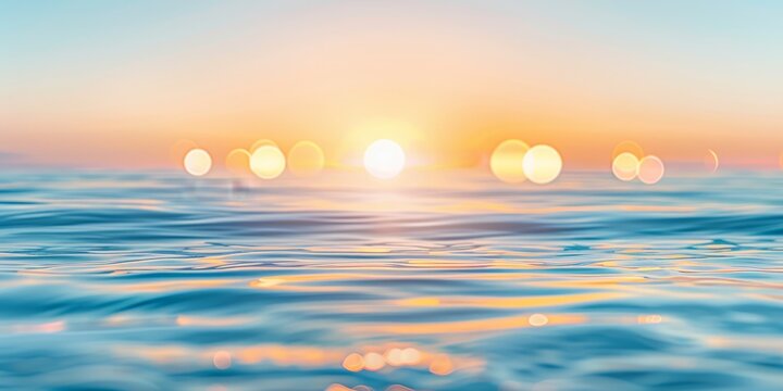 Tranquil sunset over sparkling ocean water with glowing reflections and soft pink and orange hues in the sky.