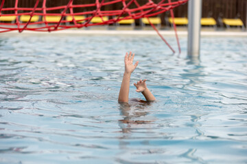 Hands of drowning person stretching out of the water in swimming pool needing help. Stress concept