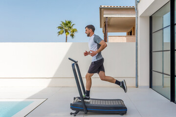 Man running on a treadmill in a luxurious outdoor setting