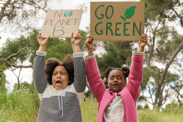 Young activists holding environmental signs in a park
