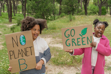 Young activists holding environmental signs in a forest