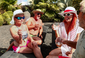 Seniors sharing laughter and drinks by the pool