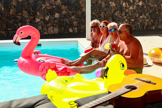 Joyful seniors relaxing at a pool with inflatable toys