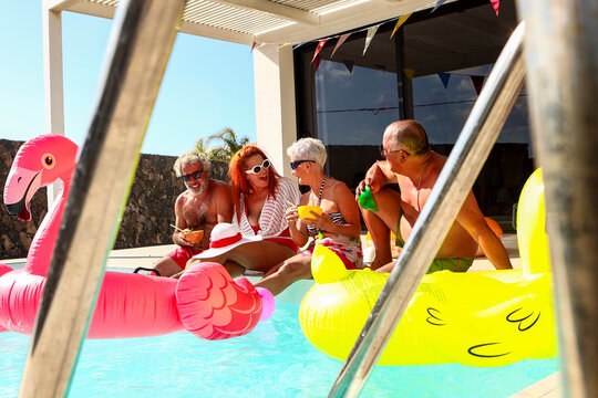 Seniors Enjoying a Sunny Pool Party with Floats