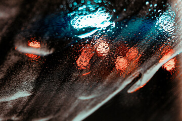 Close-up of vibrant street lights reflecting on wet surface