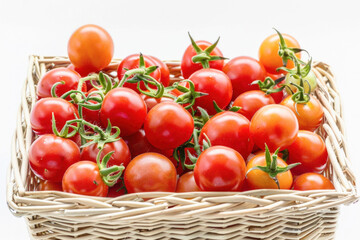 A wicker basket with tomatoes on a white background, displaying food ingredients and natural foods