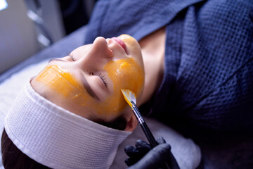A young woman does a cosmetic procedure at a beauty center or clinic.