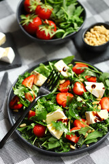 Summer salad with strawberries, arugula, Camembert cheese and pine nuts.