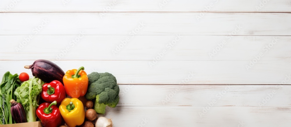 Poster Vegetables and fruits in a paper bag on a white wooden background with copy space image.