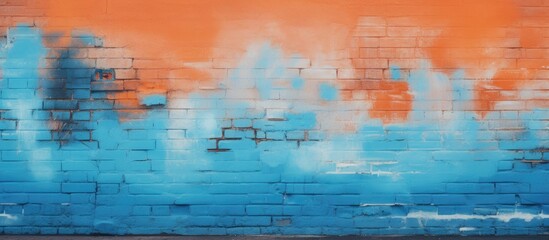 Spray-painted blue and orange colors on a brick wall with a copy space image.