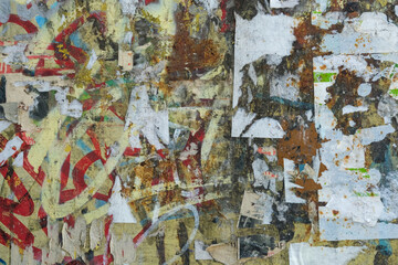 Close-up of an urban bulletin board with torn paper announcements and layered posters, showcasing a textured and chaotic composition of colors and materials