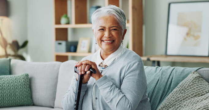 Woman, senior and portrait with cane on sofa, walking support and assistance stick in retirement home on weekend break. Smile, happiness and elderly female person with a disability, wellness and help - Powered by Adobe