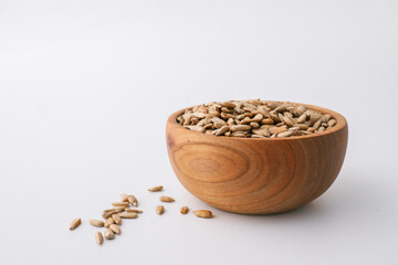 Sunflower seeds in wooden bowl isolated on white background