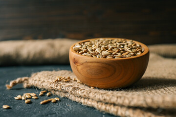 Sunflower seeds in wooden bowl on a rural background