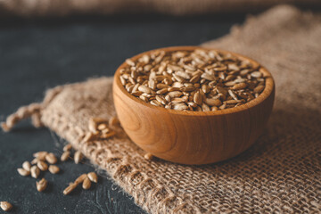 Sunflower seeds in wooden bowl on a rural background